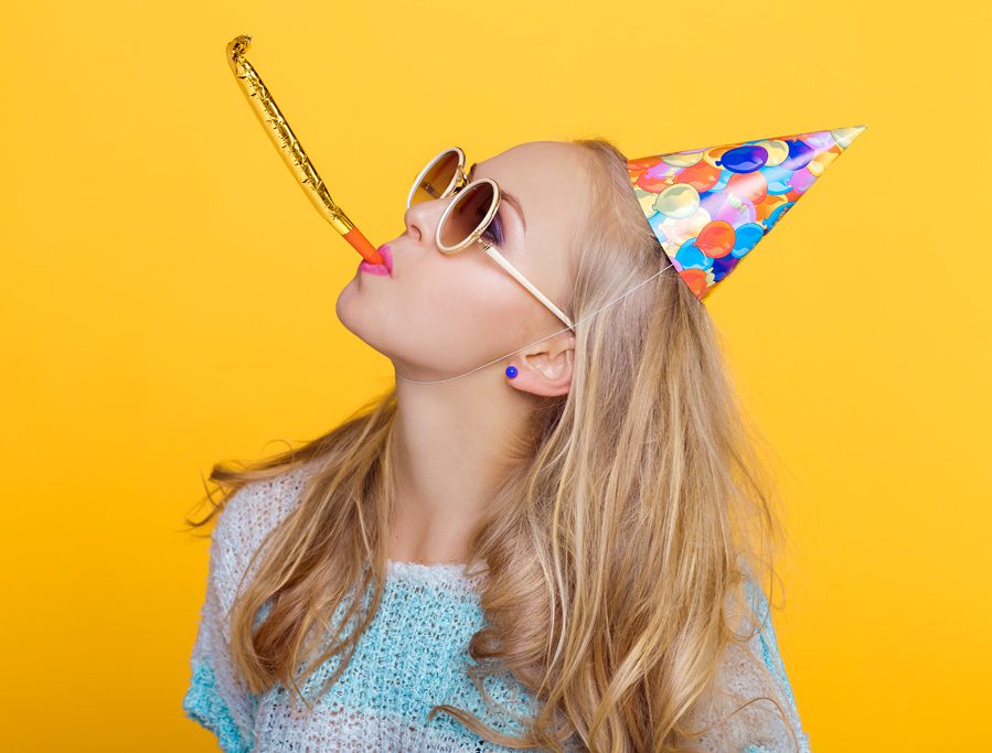 A woman wearing glasses and a party hat.