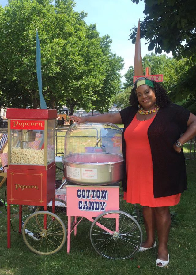 A woman standing next to a candy cart.