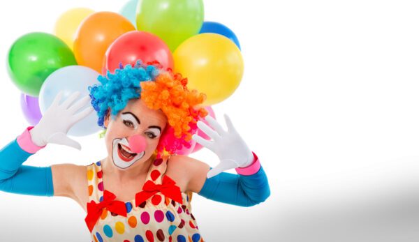 A clown with balloons on his head and gloves