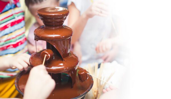 A chocolate fountain is being used to make chocolate.