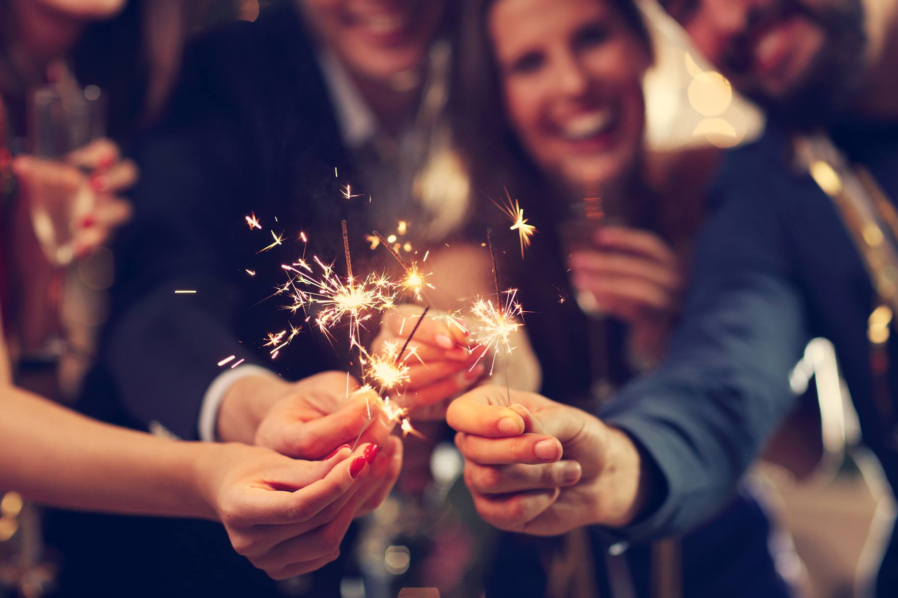 A group of people holding sparklers in their hands.