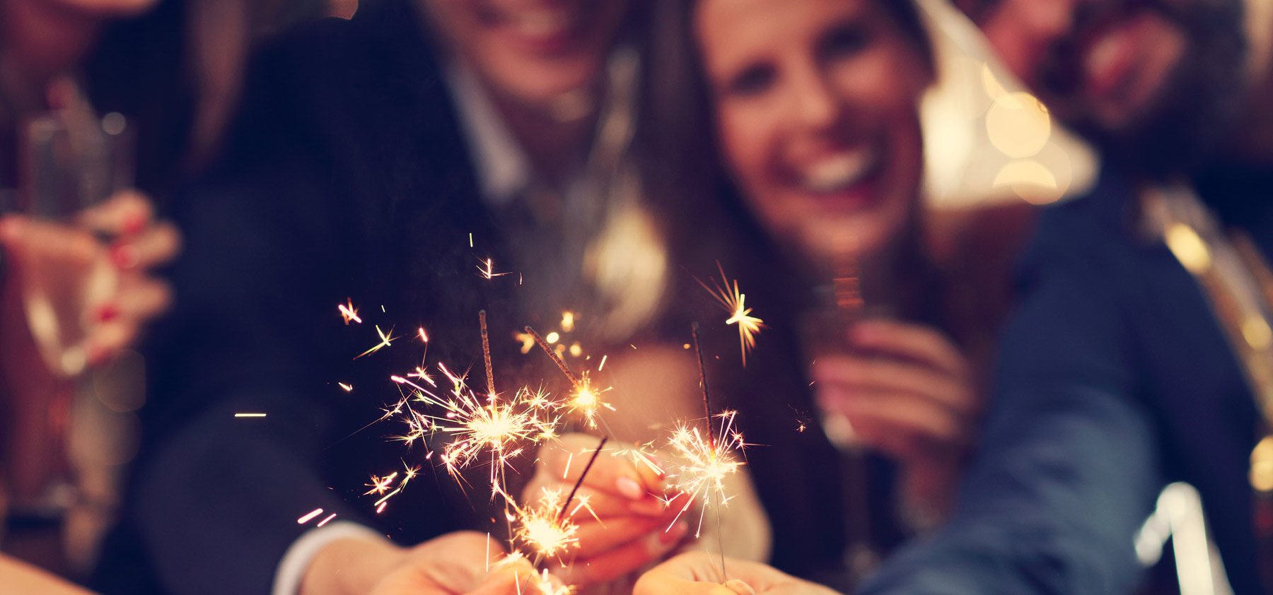 Two people holding sparklers in their hands.