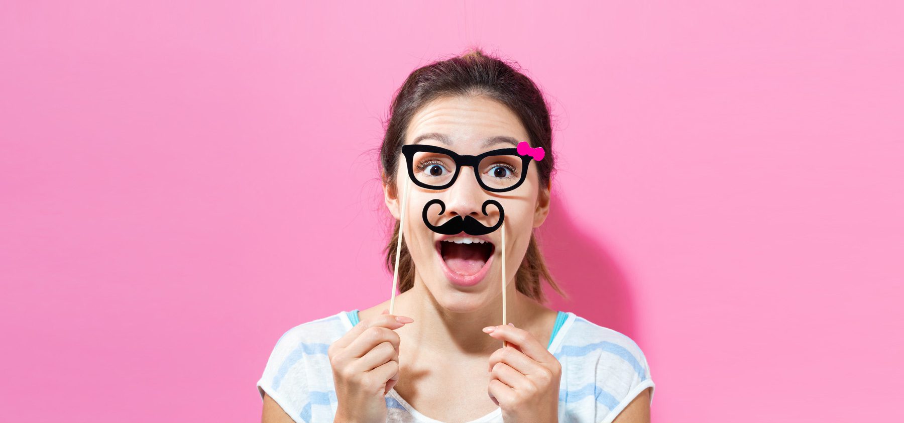 A woman with fake mustache and glasses on sticks.