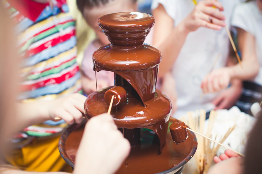 A chocolate fountain is being poured into the table.