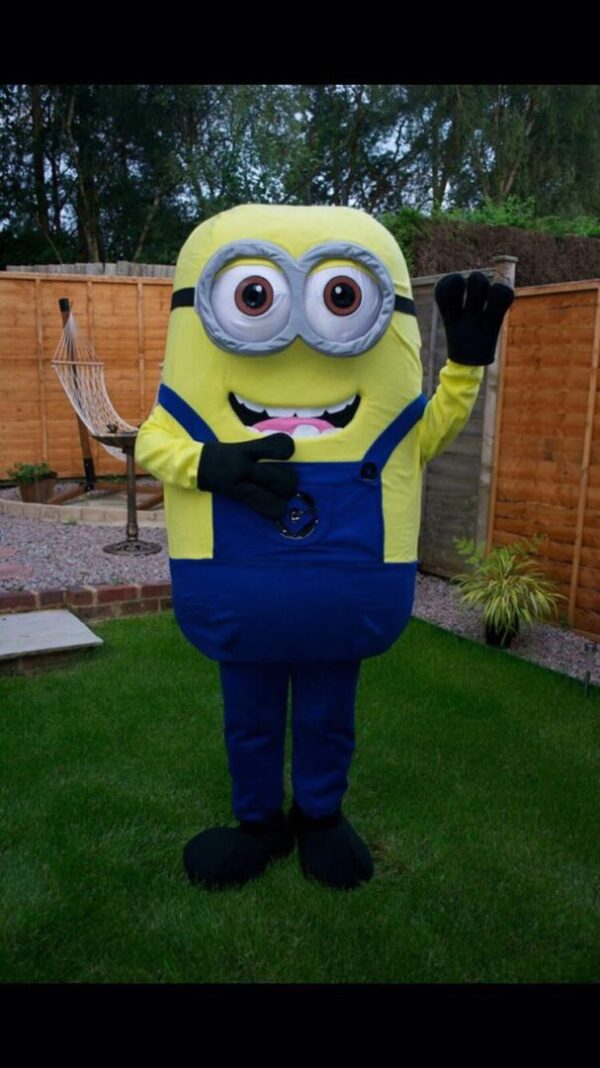 A person in a minion costume standing on the grass.