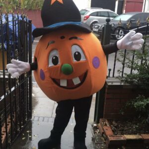 A person in costume standing on the sidewalk.