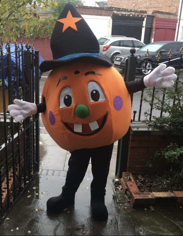 A person in costume standing on the sidewalk.