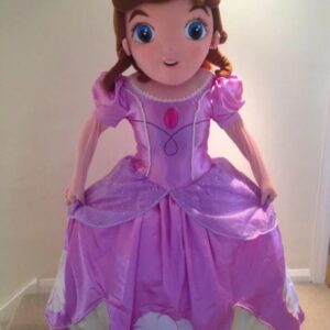 A large doll dressed in purple dress and hair.