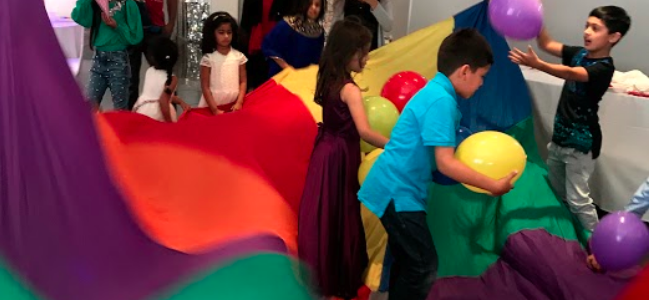 A group of children playing with balloons in an indoor play area.